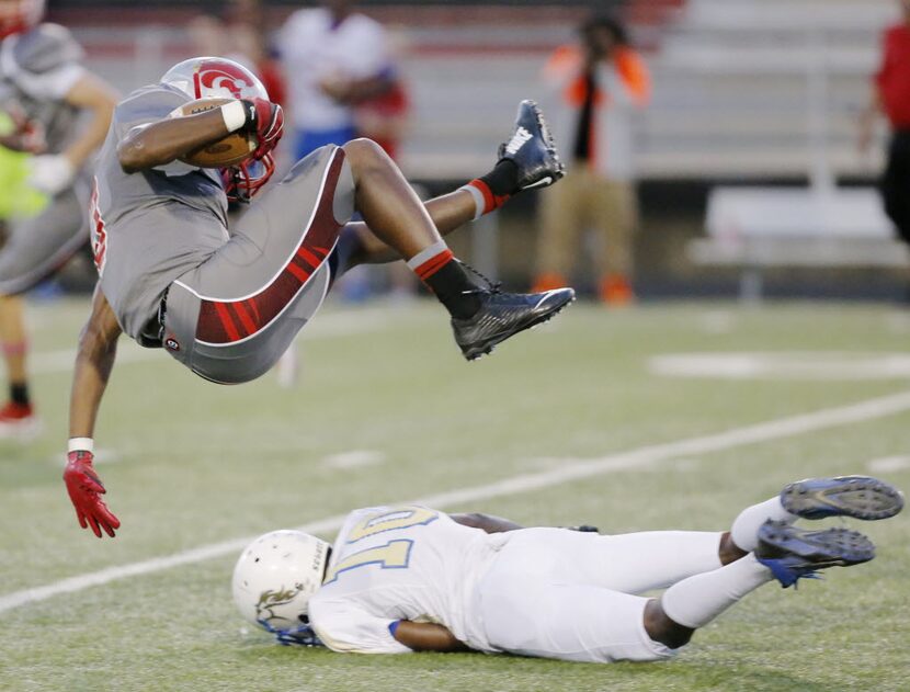 TXHSFB Woodrow Wilson junior kickoff returner Justin Cain (3) leaps over Conrad senior...