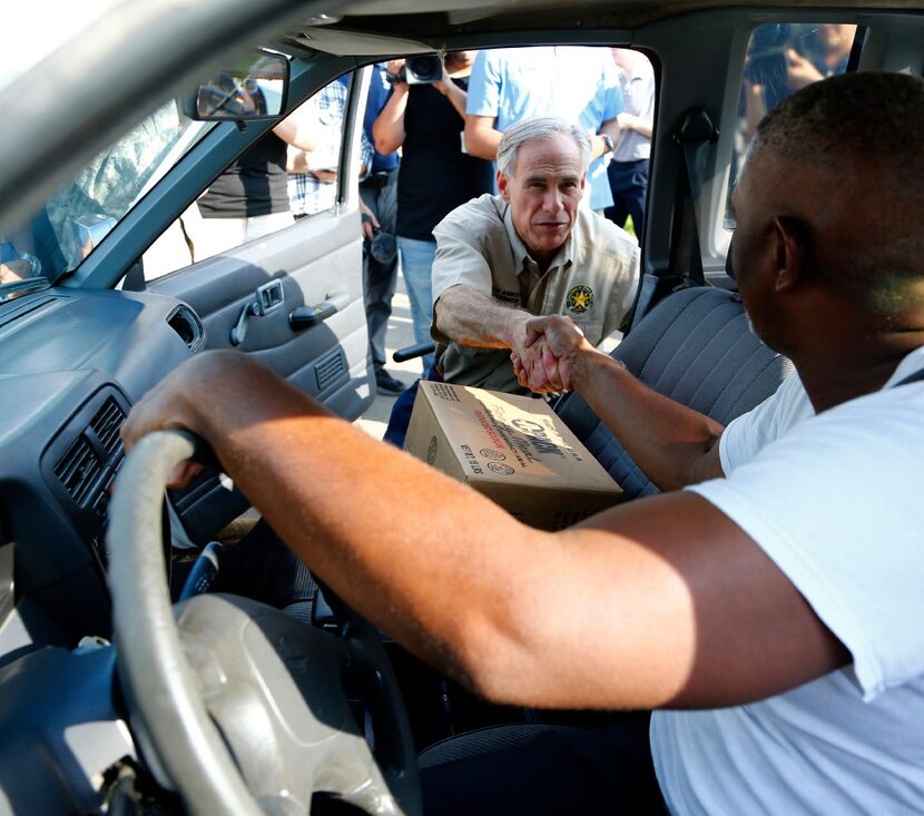 Texas Gov. Greg Abbott shakes the hand of Wesley Mouton from Beaumont during a visit to Ozen...