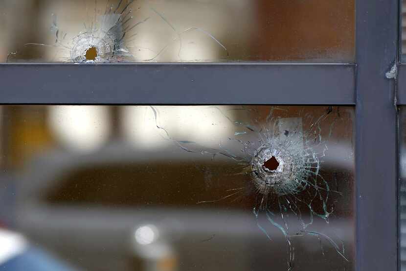 Two bullet holes in the windows of El Centro College are seen at the scene where the five...