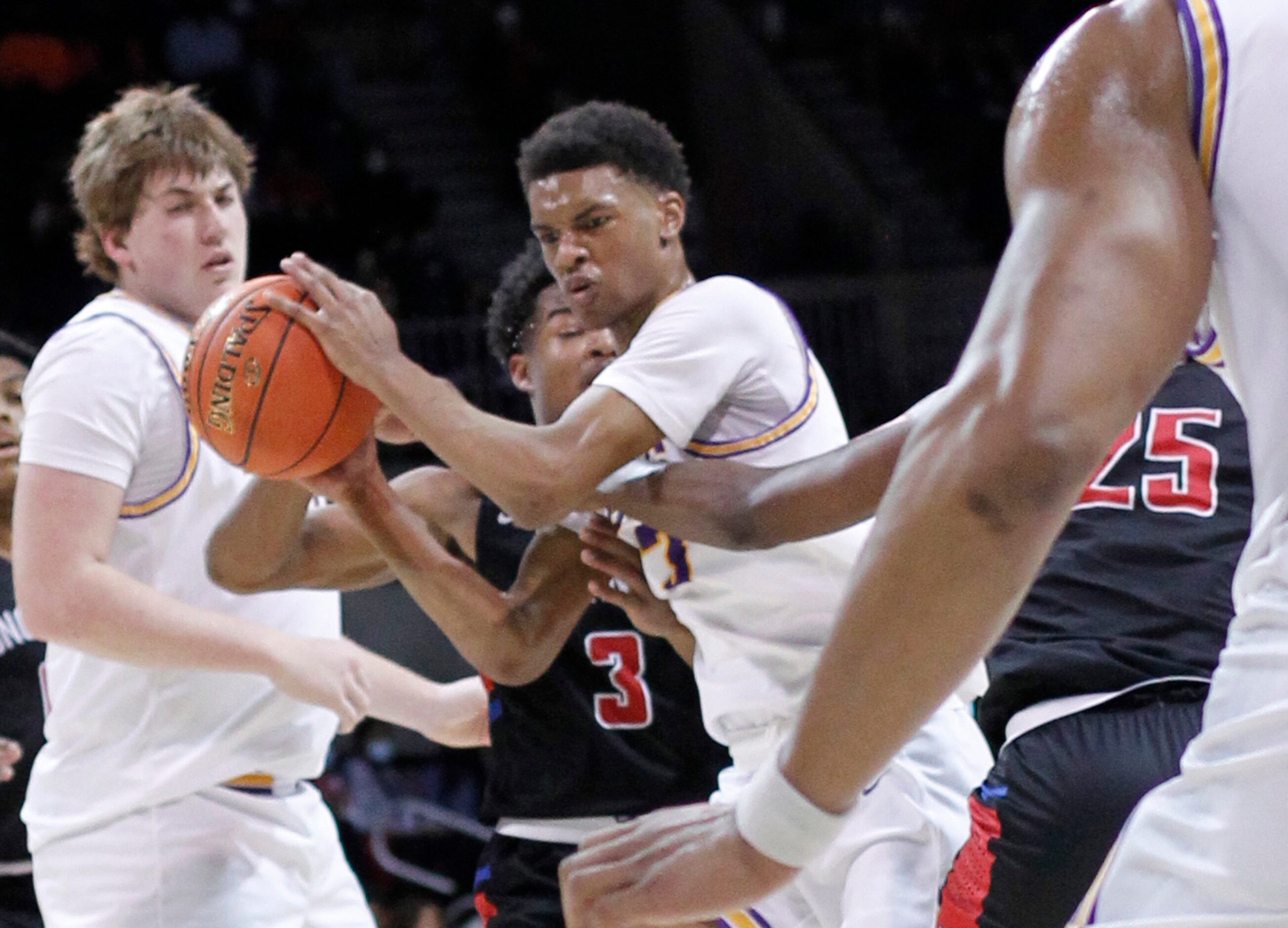 Richardson guard Rylan Griffen (3), center,  grimaces as he dribbles through congestion...