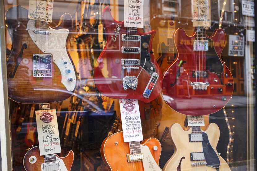 
guitars hang from the walls of the NO.TOM guitar shop on Denmark Street in London. The...