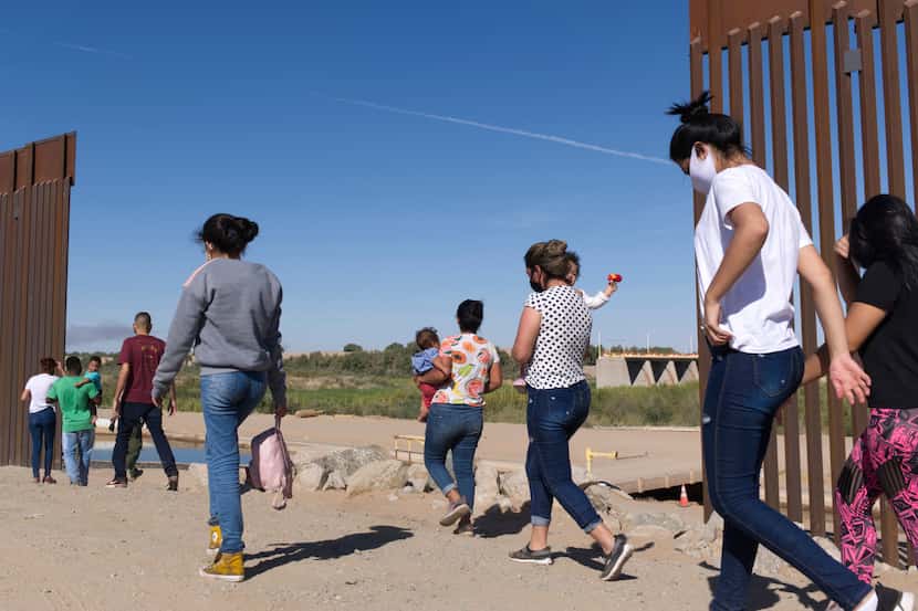Un grupo de migrantes brasileños ingresan a Estados Unidos desde México por una brecha del...