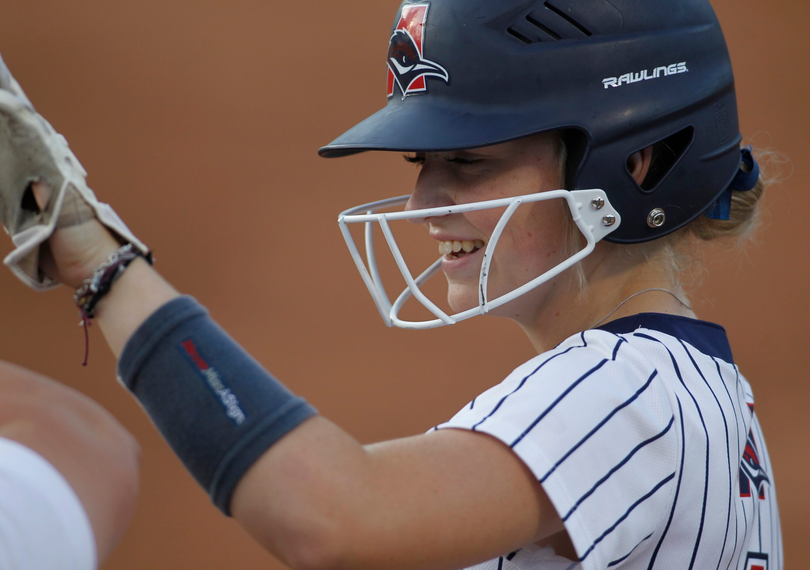 Aubrey's Bree Jones (1) celebrates her single with her first base coach during the bottom of...