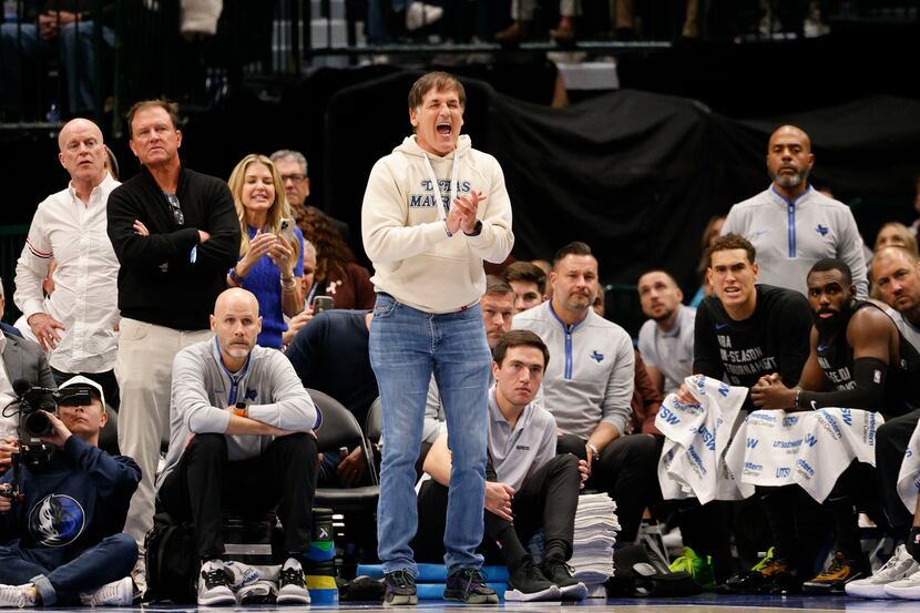 Dallas Mavericks owner Mark Cuban, center, cheers during the second half of an NBA...