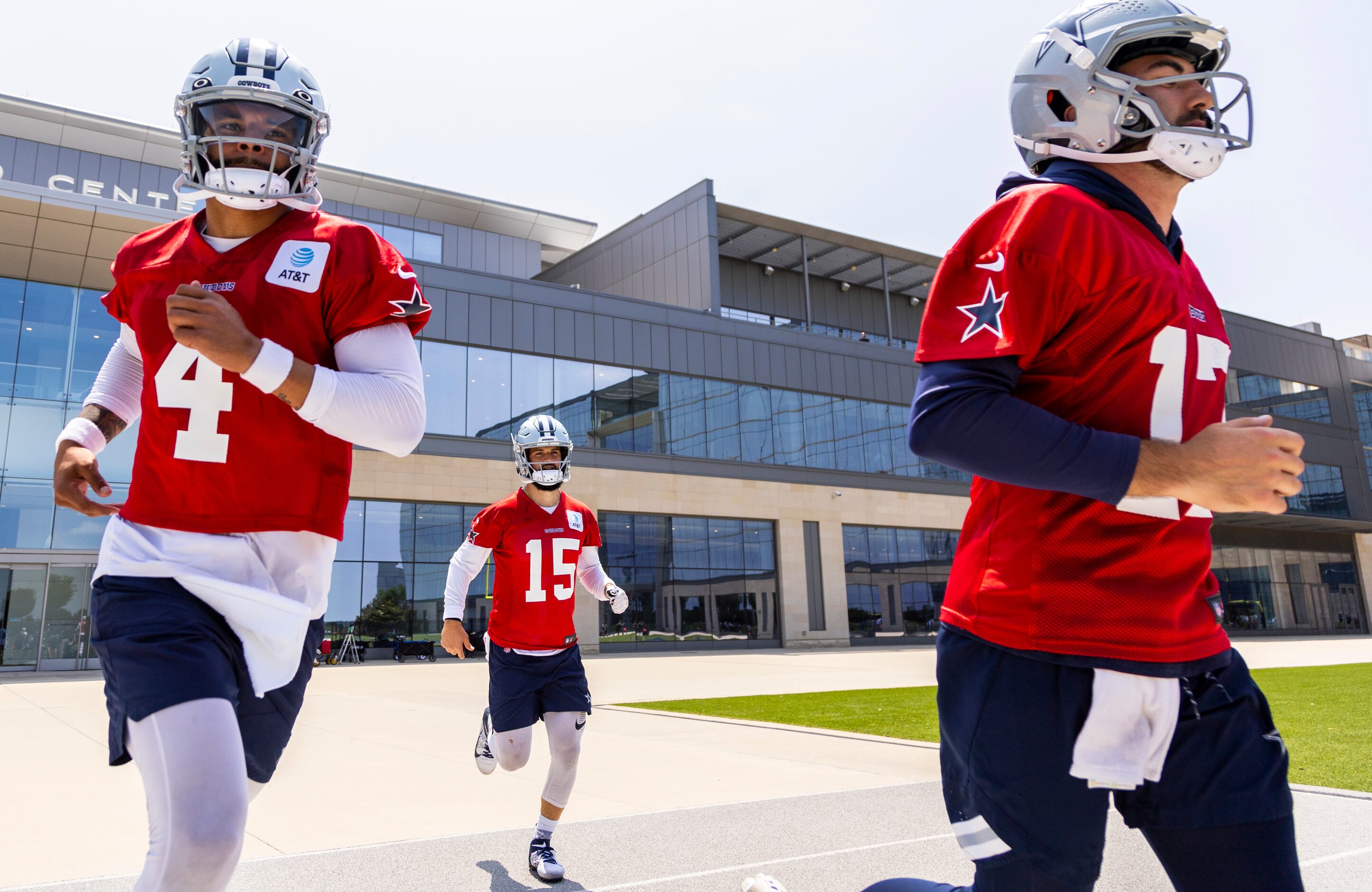 Dallas Cowboys quarterback Dak Prescott (4), Will Grier (15) and Ben Dinucci (17) take the...