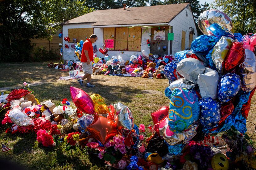 Chris Garza visits the growing tribute to Shavon Randle filling the yard of the abandoned...