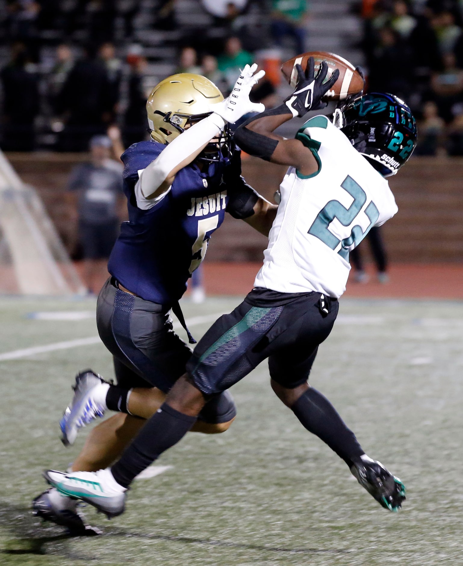 Richardson Berkner high WR Dameon Crowe (22) makes a catch over Jesuit’s Logan Thompson (5)...