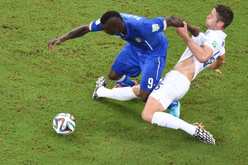 Italy's forward Mario Balotelli (left) and England's defender Gary Cahill vie for the ball...