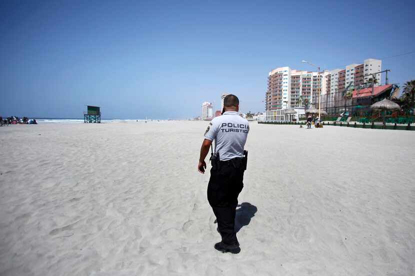 Rosarito Beach tourist police officer Roberto Casas patrols a massive but empty beach during...