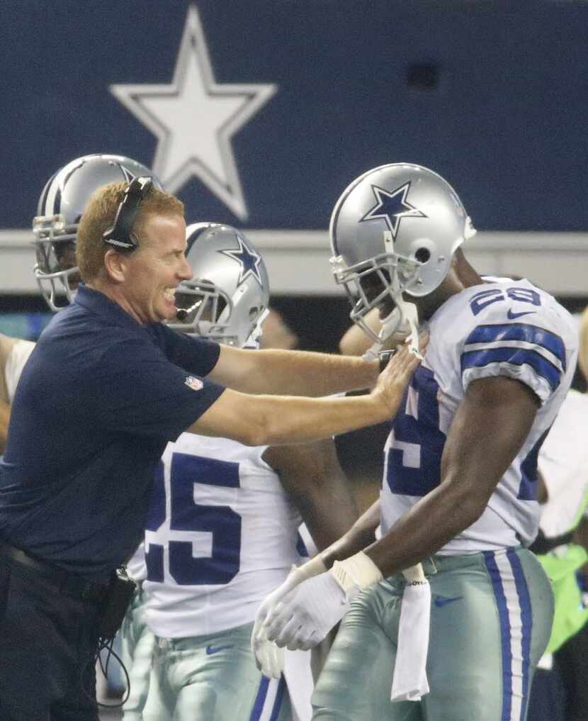 Cowboys head coach Jason Garrett playfully shoves running back DeMarco Murray after his...