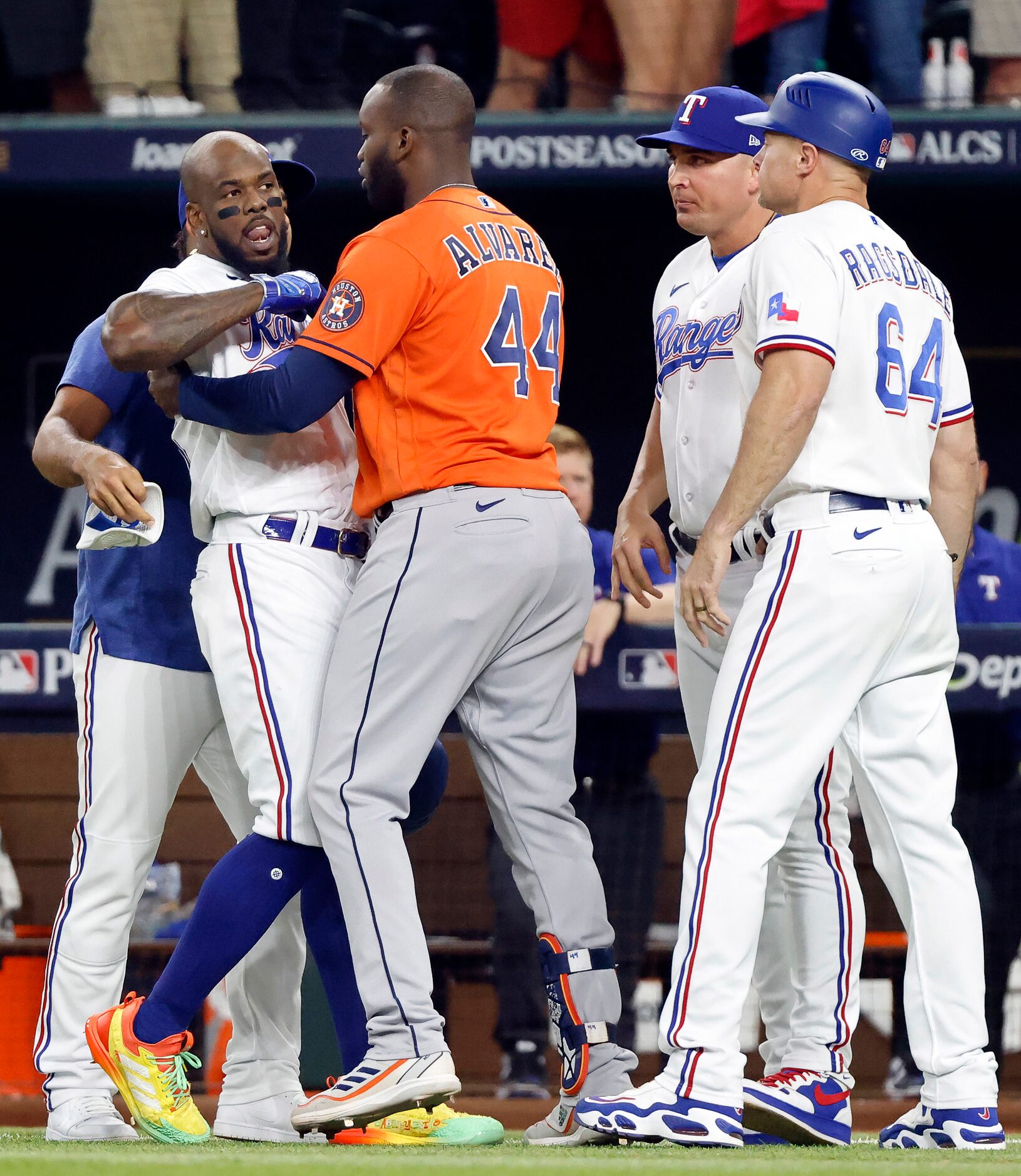 Houston Astros designated hitter Yordan Alvarez (44) restrains Texas Rangers right fielder...