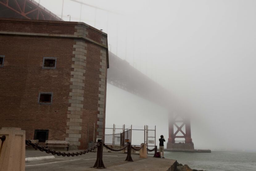 In this photo taken Thursday, Sept. 27, 2012, a man stands beside Fort Point and looks out...