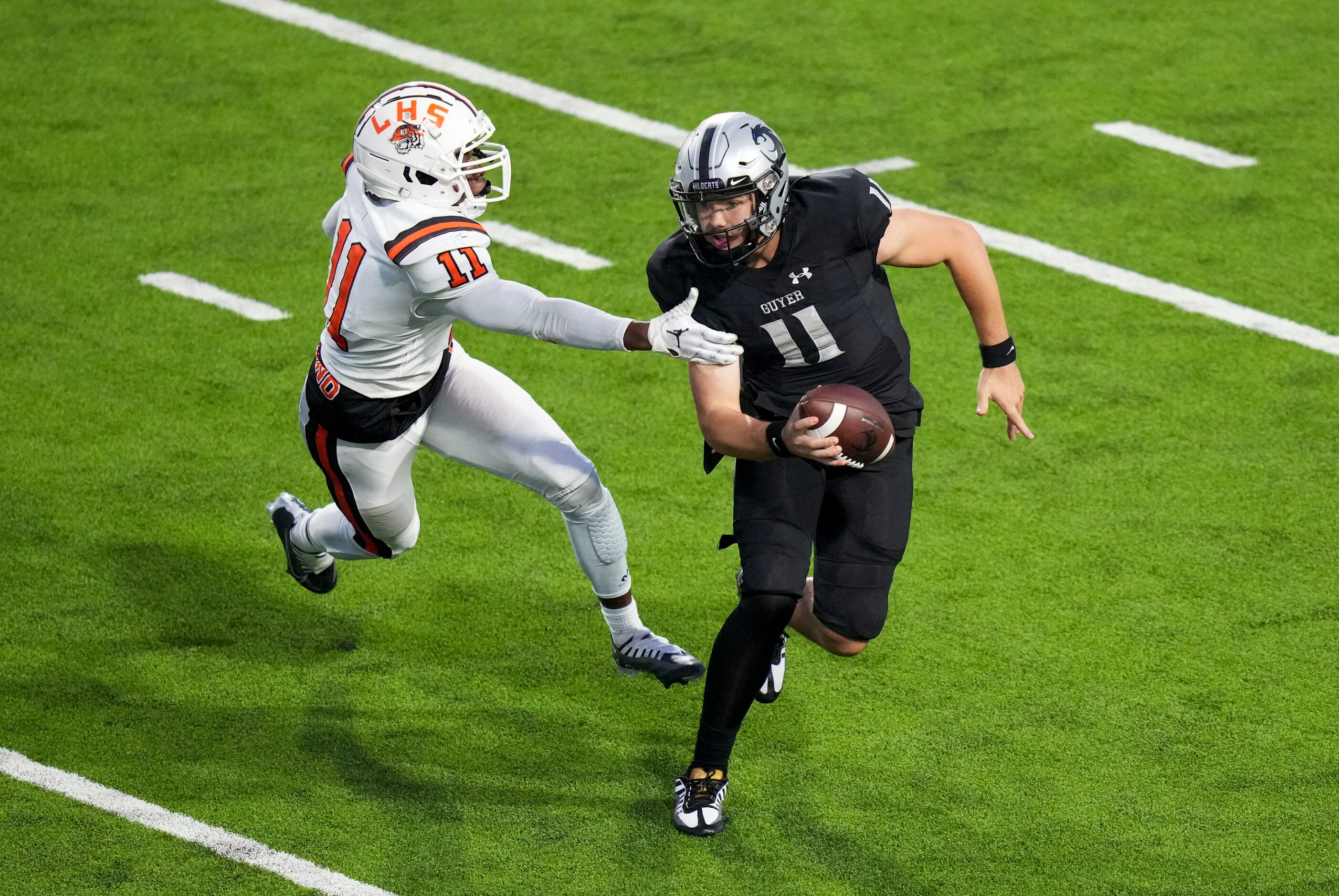 Denton Guyer quarterback Jackson Arnold (right) gets past Lancaster defensive lineman...