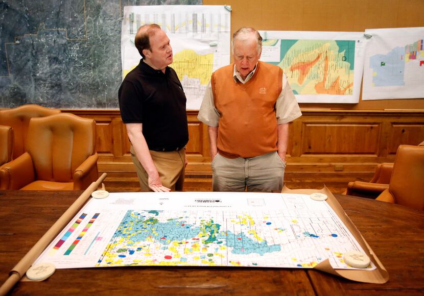 Dallas Morning News reporter Alan Peppard (left) pores over an oil and gas map with T. Boone...