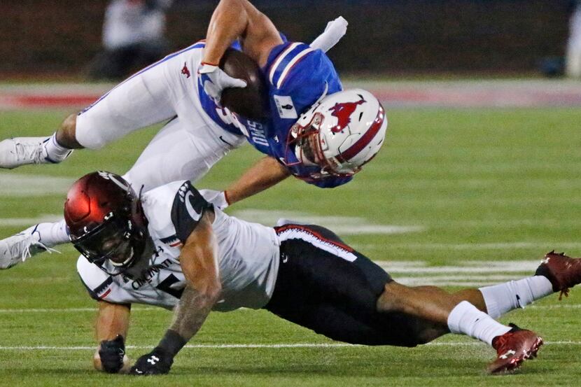 Southern Methodist Mustangs wide receiver Tyler Page (4) is upended byCincinnati Bearcats...