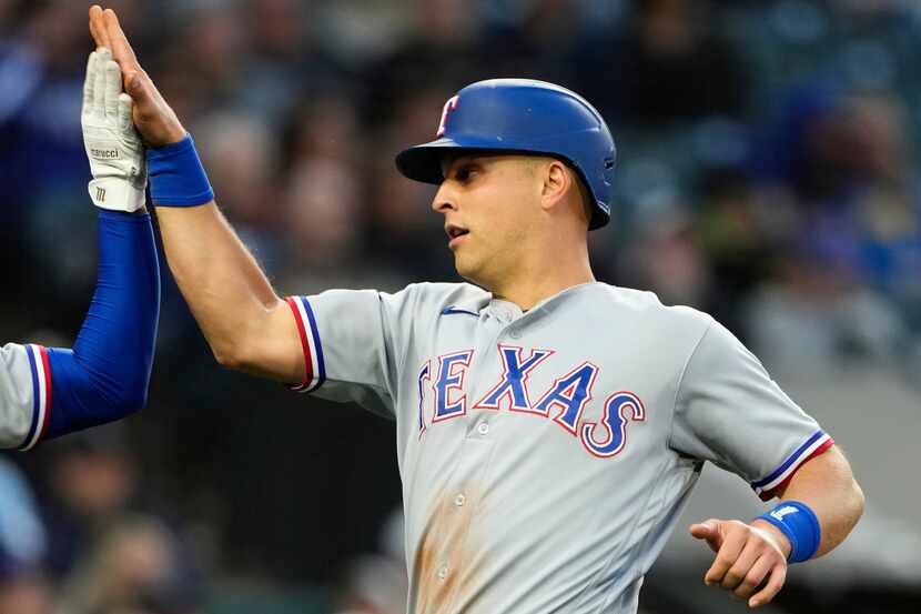 Texas Rangers' Ezequiel Duran (20) greets Nathaniel Lowe as Lowe scores on a single by Jonah...