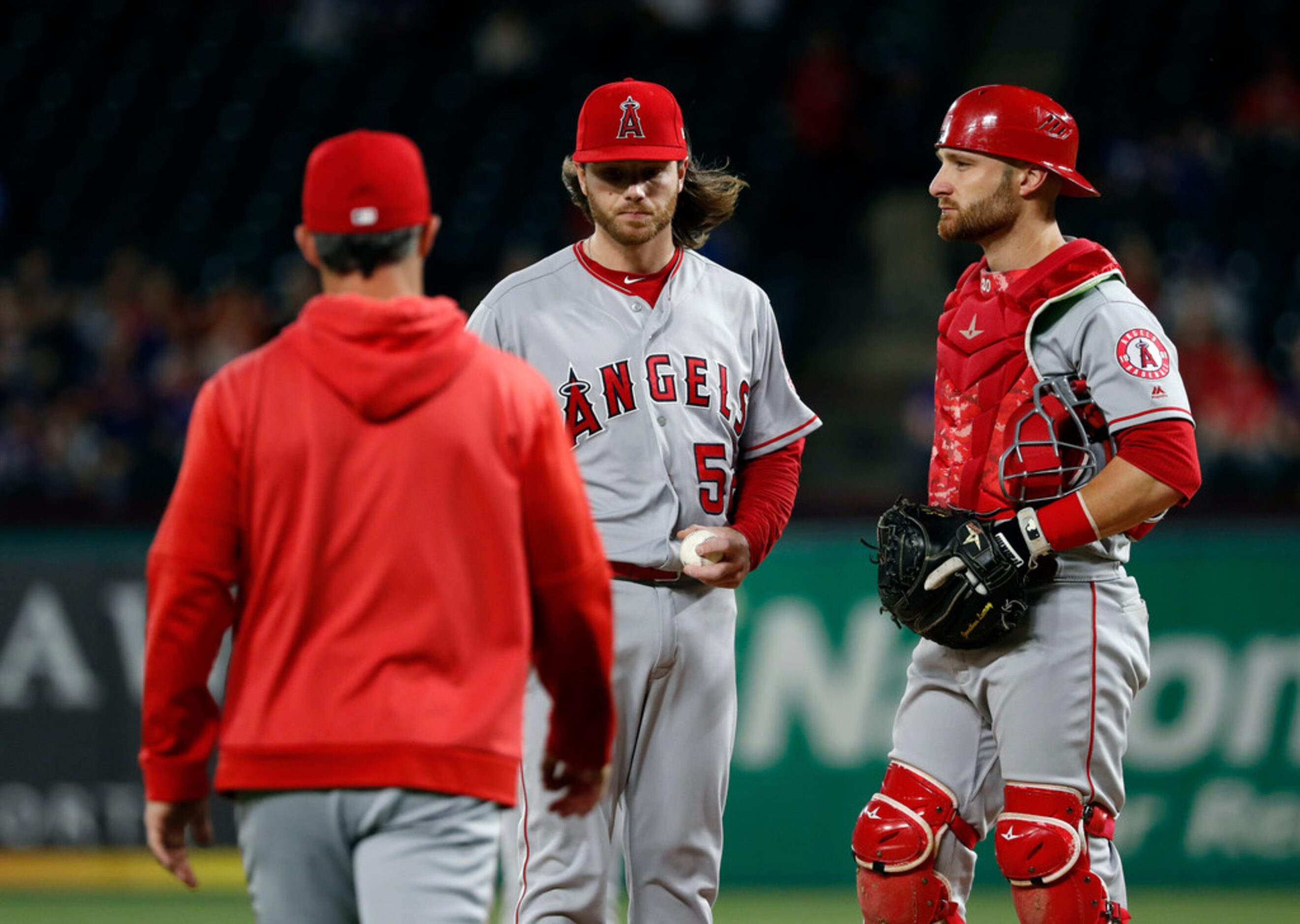 Los Angeles Angels manager Brad Ausmus, left, walks out to take the ball from relief pitcher...