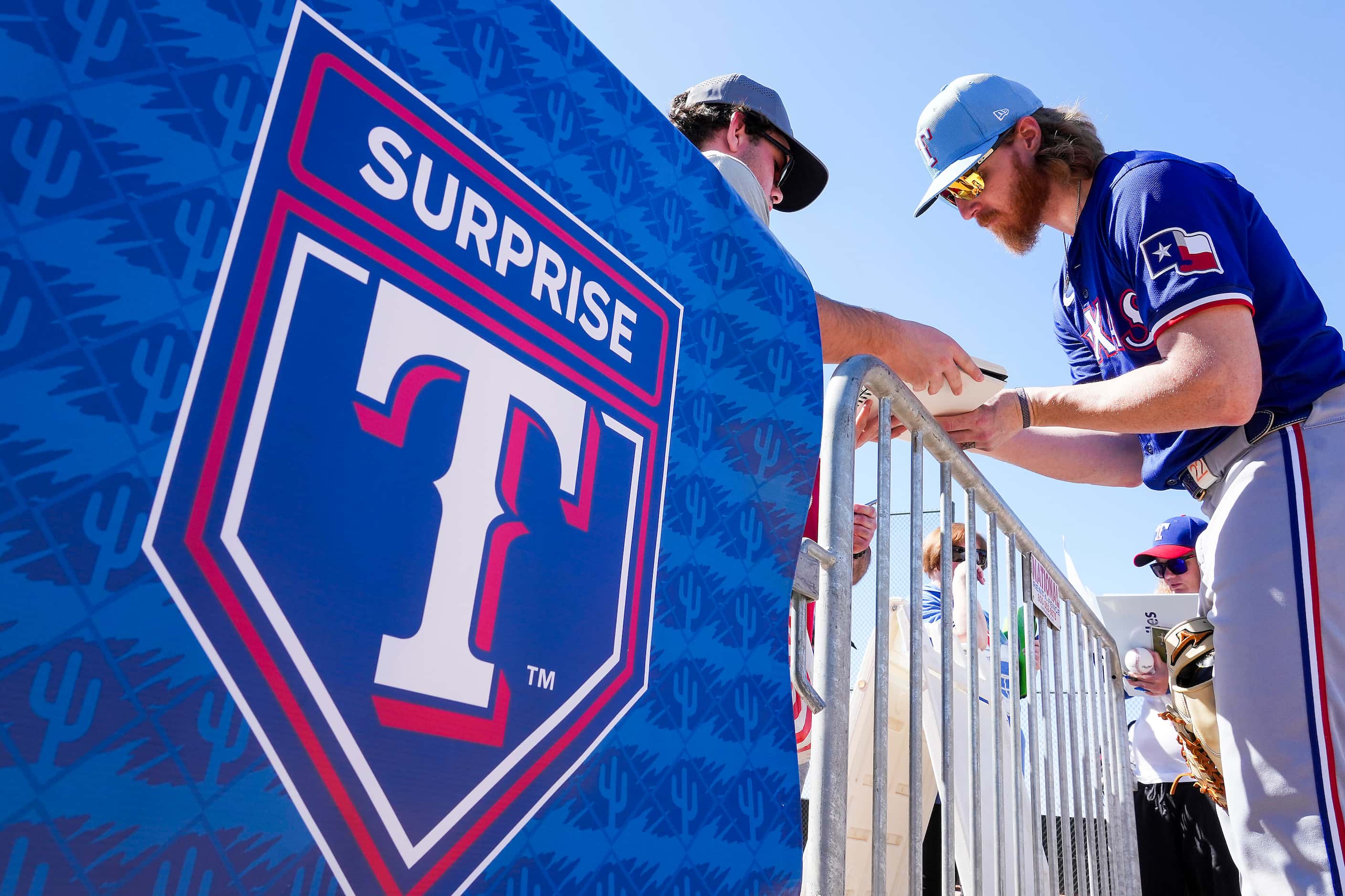 Texas Rangers pitcher Jon Gray signs autographs following a spring training workout at the...