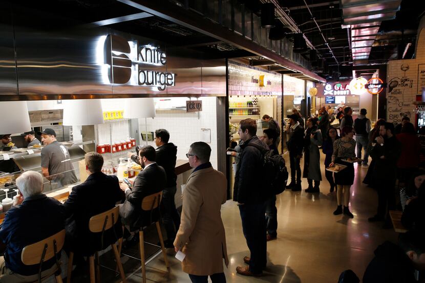 People wait in line at knife burger as others make their way around Legacy Hall during the...