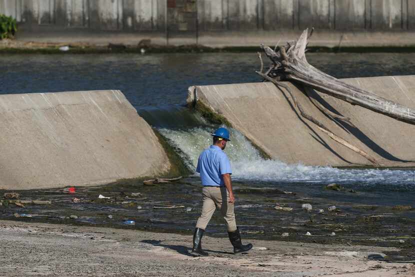 Officials survey the spillway at White Rock Lake on Thursday, July 25, 2019 in Dallas.