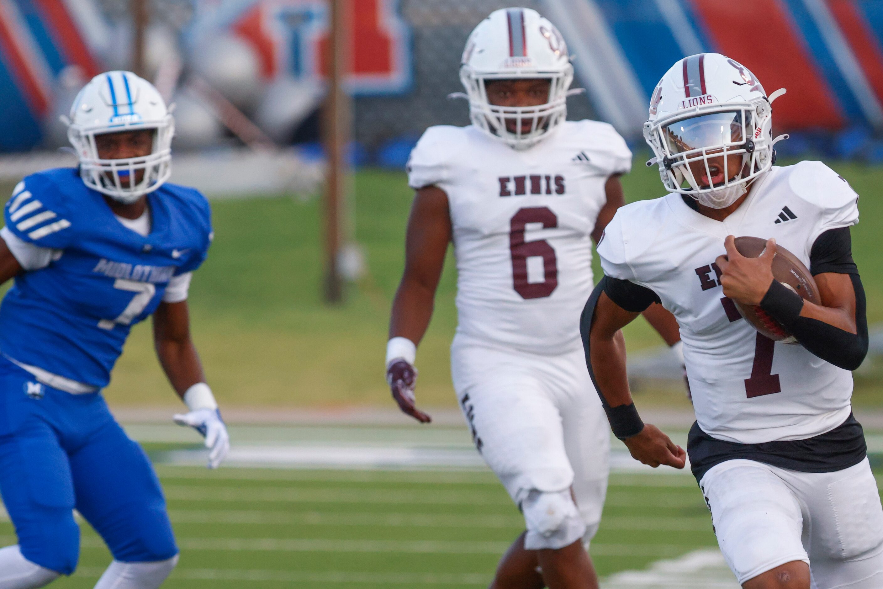 Ennis’ QB Wondame Davis Jr. (right) runs for a yardage during the first half of a football...