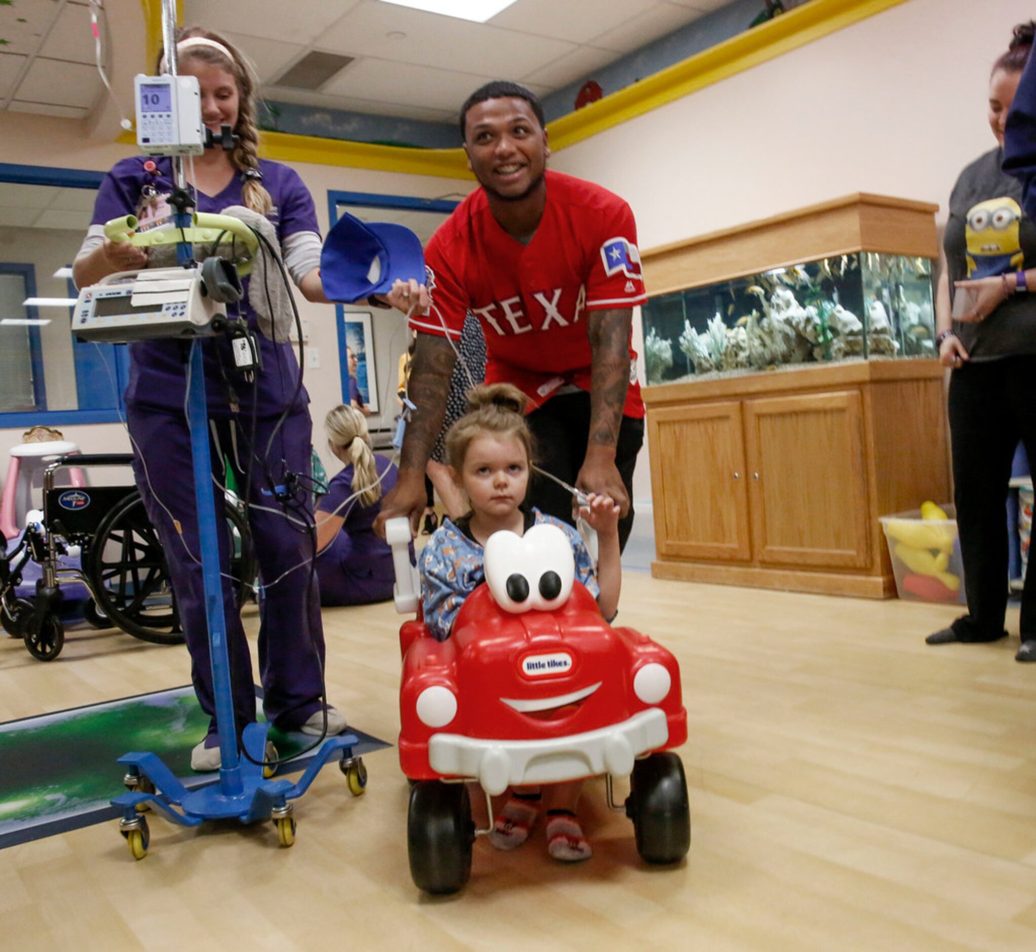 Texas Rangers outfielder Willie Calhoun pushes 5-year-old Lynnlee Fedro while playing at...