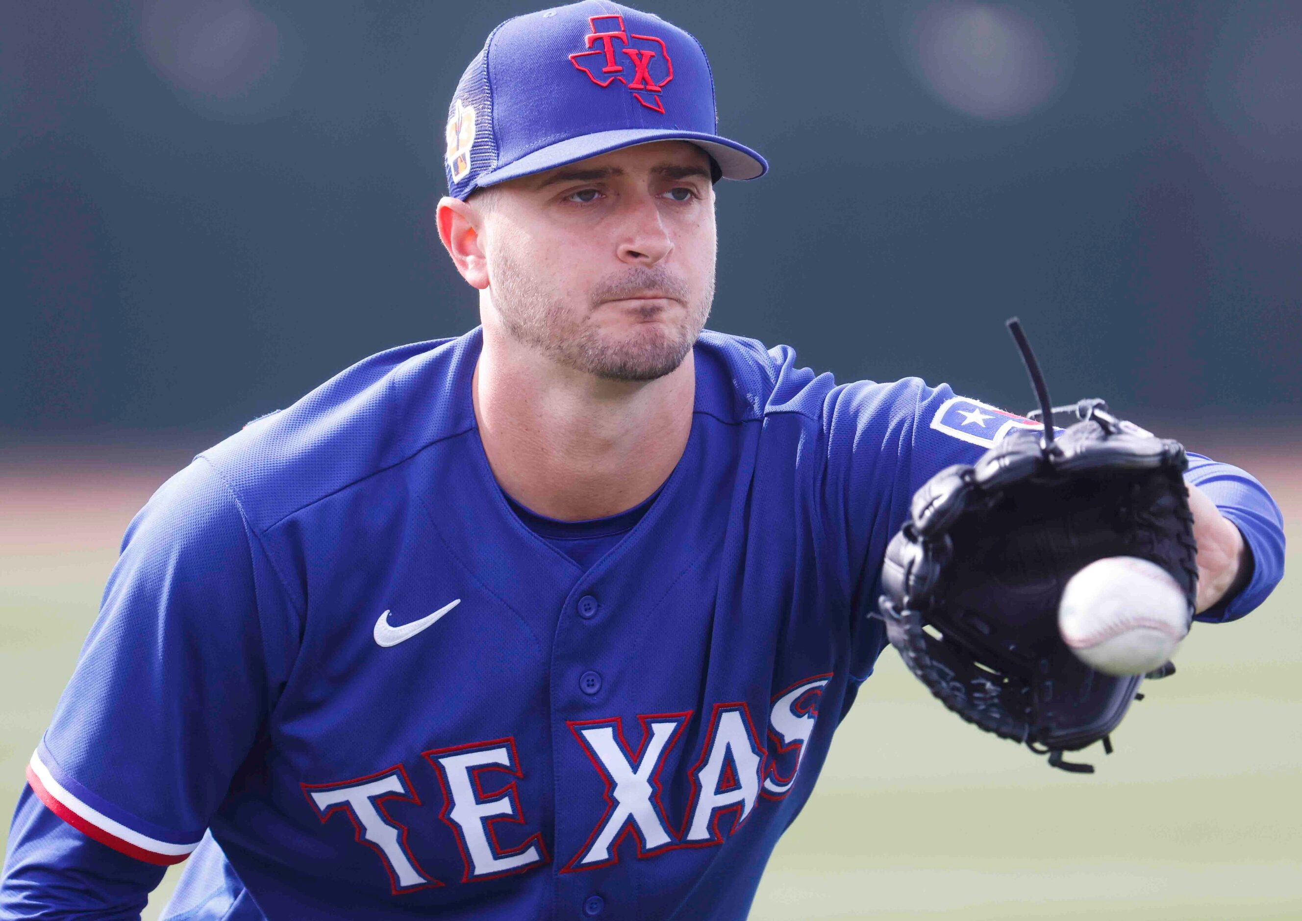 Texas Rangers pitcher Jake Odorizzi warms up before spring training workout at the team's...