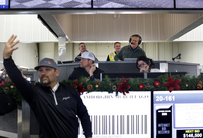 Auctioneers, led by John Clay Wolfe, upper right, take bids during an auction at Manheim in...