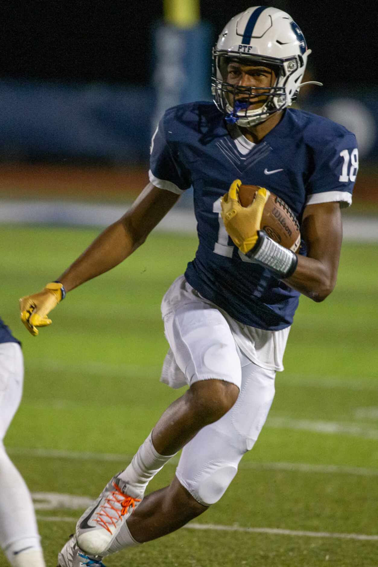 All Saints' wide receiver Ben Patterson makes a run after catching the ball during a game...