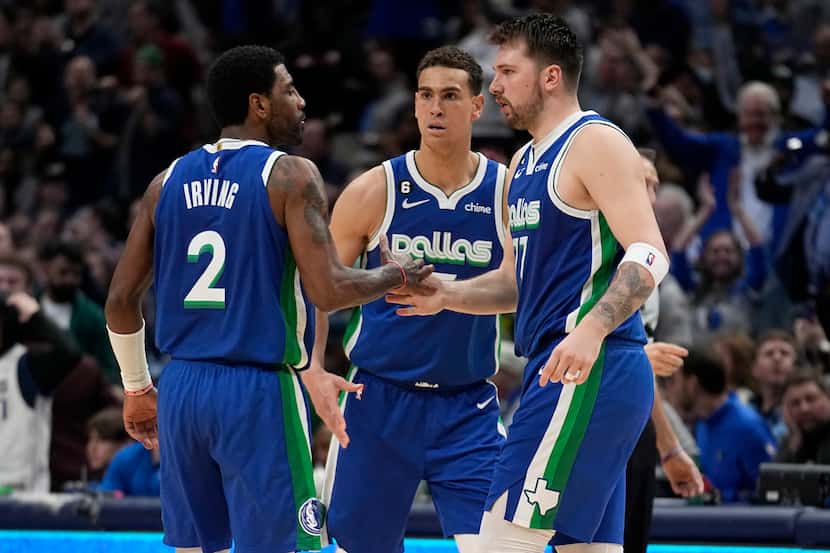 Dallas Mavericks' Kyrie Irving (2), Dwight Powell, center, and Luka Doncic, right, celebrate...
