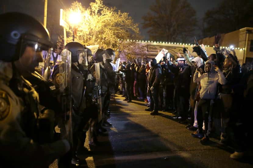 Police officers stood guard as protesters reacted to the announcement of the grand jury...