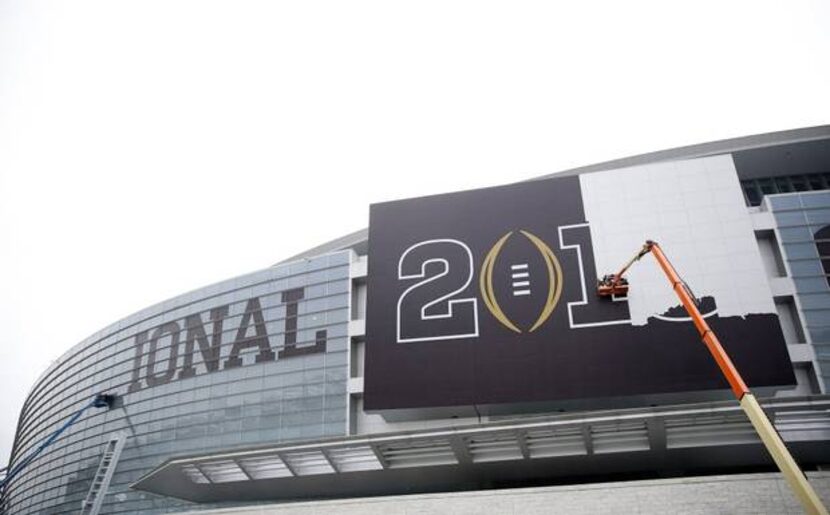 Crews remove College Football Playoff National Championship game signage from AT&T Stadium...