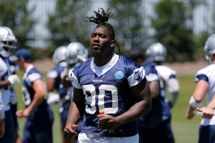 Dallas Cowboys defensive end Demarcus Lawrence (90) jogs off the field after an NFL football...