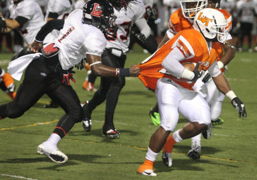 Mansfield Legacy junior wide receiver Terrance Ivery (1) grabs the jersey of  Lancaster...