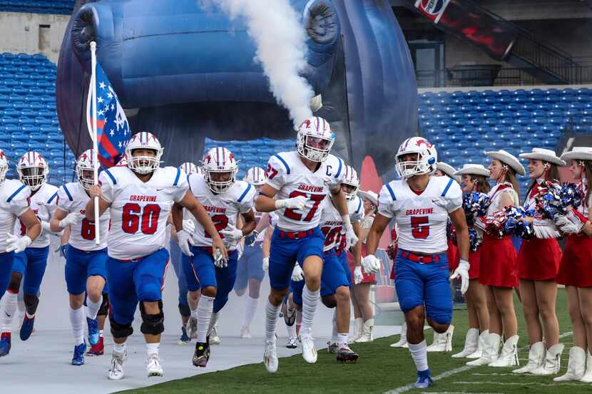 Grapevine High School players run on the field at Toyota Stadium before the football game...