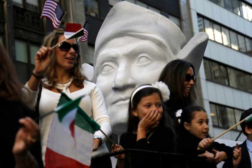 In this 2015 photo, participants in New York's Columbus Day Parade ride a float with a large...