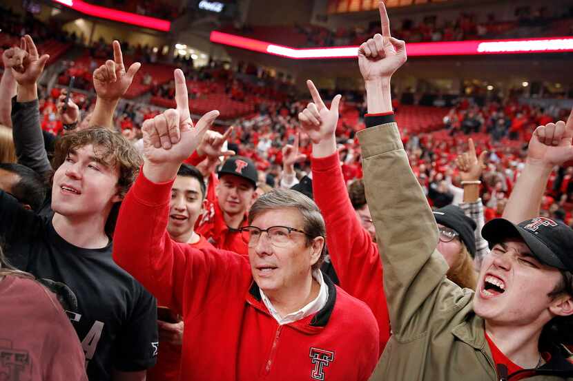 Texas Tech Red Raiders head coach Mark Adams (center) raises his hand in the school sign...