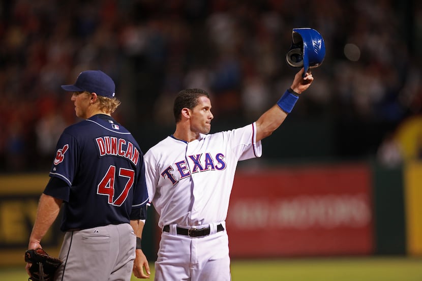 The Texas Rangers Michael Young tips his hat to the fans after hitting his 2000th hit in the...