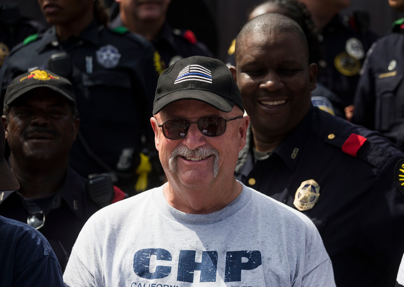 David Kling poses for a photograph with members of the Dallas Police Department during a...