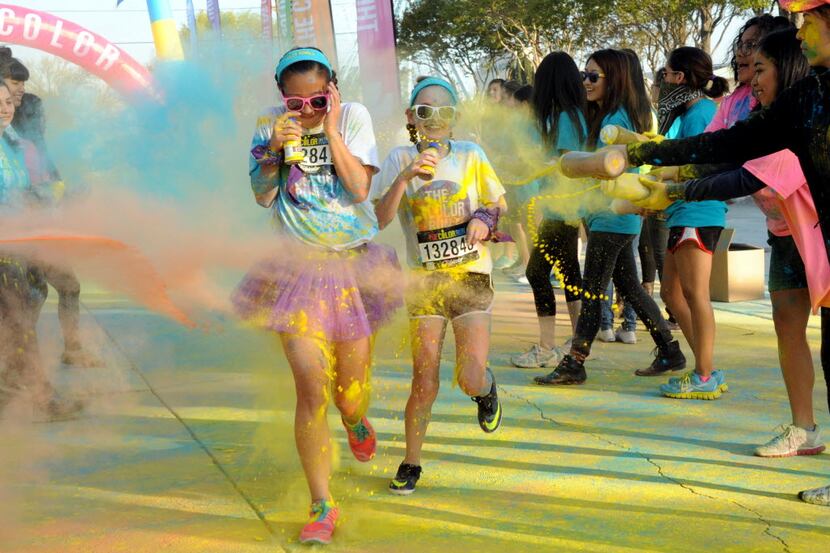 Runners race through the colored powder at the Color Run in Fair Park Dallas, TX on March...