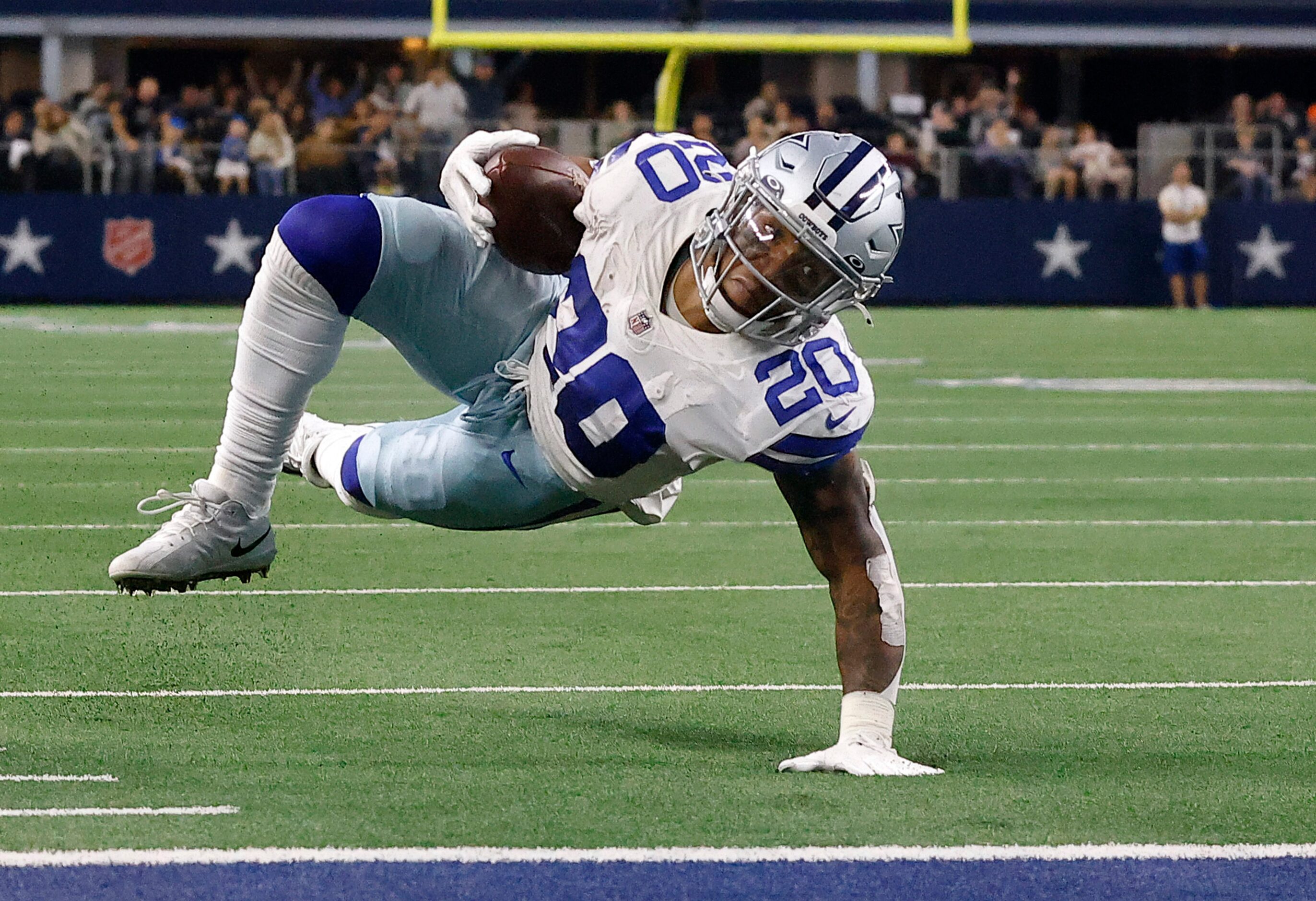 Dallas Cowboys running back Tony Pollard (20) tries to keep his balance as he eyes the goal...