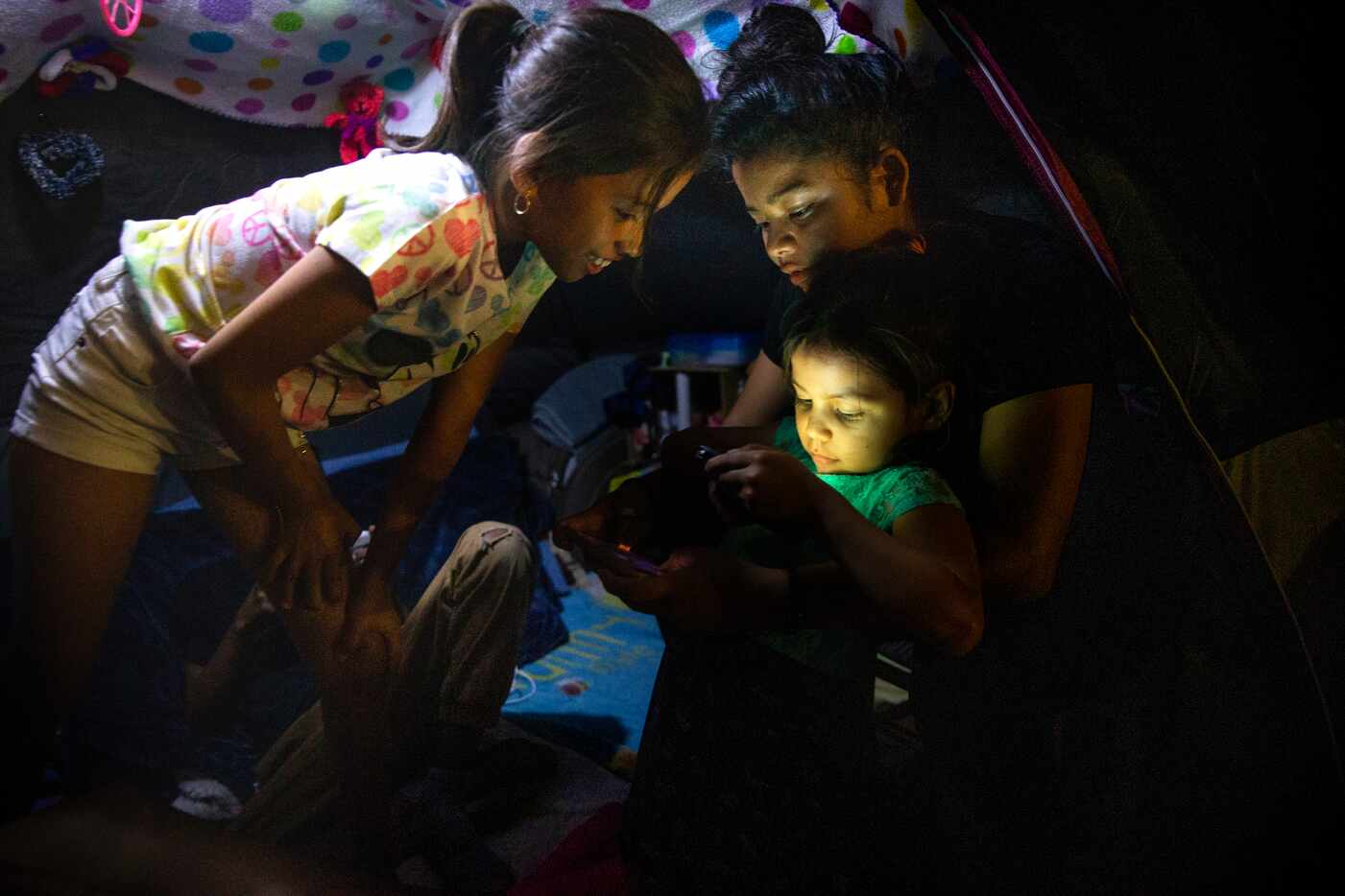 Honduran asylum-seeker Ashlee Sanchez, 14 (center) holds Naomi, 6, as they and Genesis...