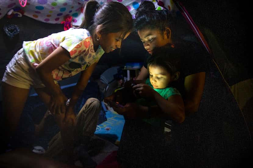 Honduran asylum-seeker Ashlee Sanchez, 14 (center) held Naomi, 6, as they and Genesis...