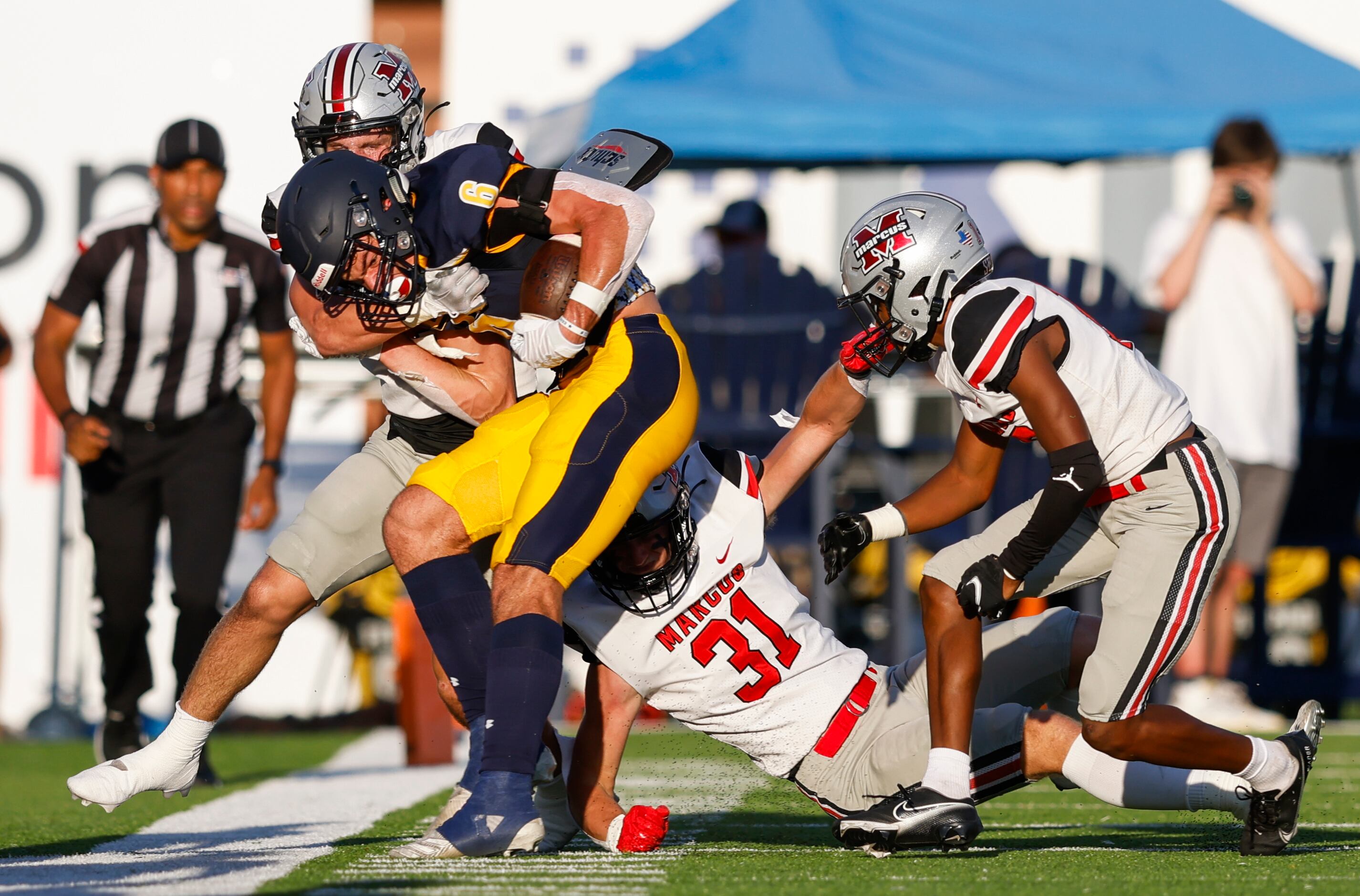 Highland Park wide receiver Luke Herring is brought down by the Flower Mound Marcus defense...