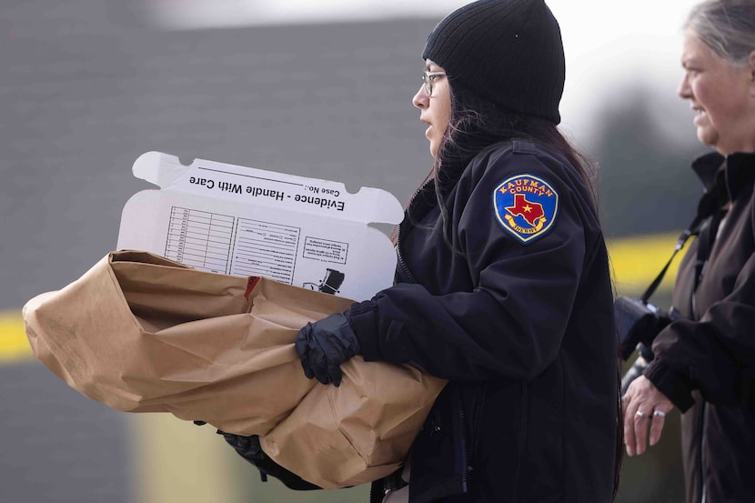 A member of the Kaufman County Sheriff department carries an evidence box as they...