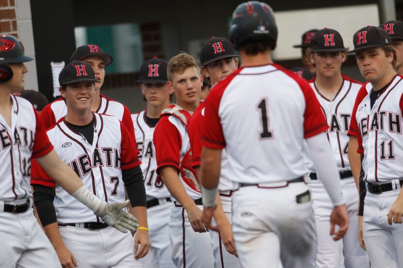 Rockwall Heath outfielder Casey Curtain (1) was greeted by stares from his teammates after...