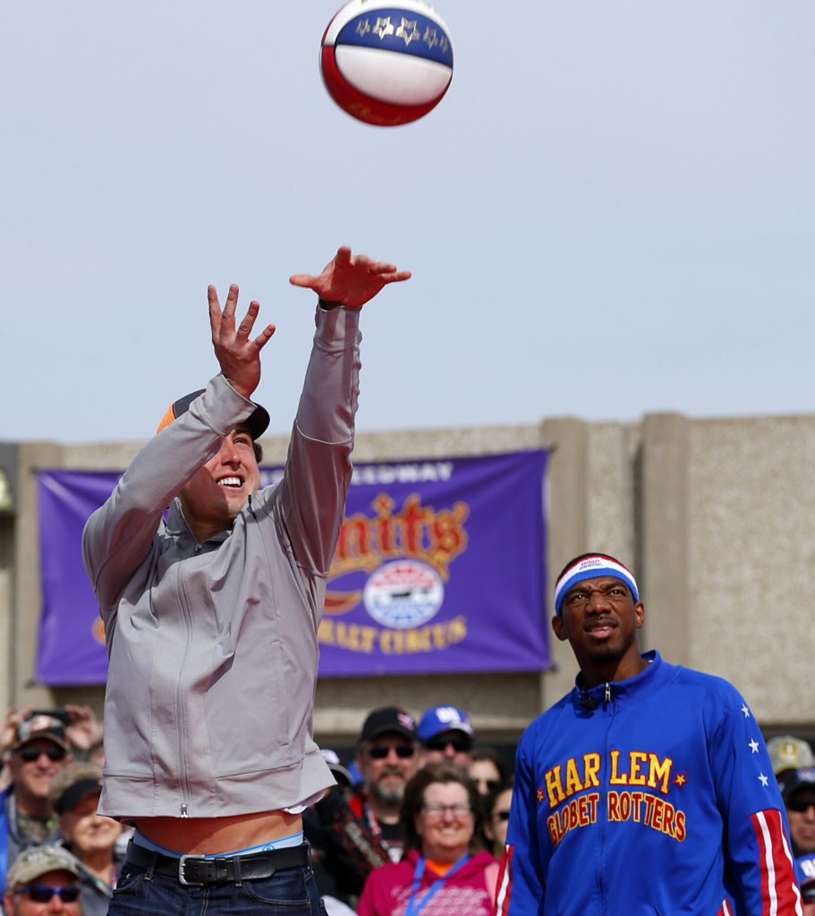 Texas Rangers pitcher Derek Holland shoots hoops with the Harlem Globetrotters during the No...