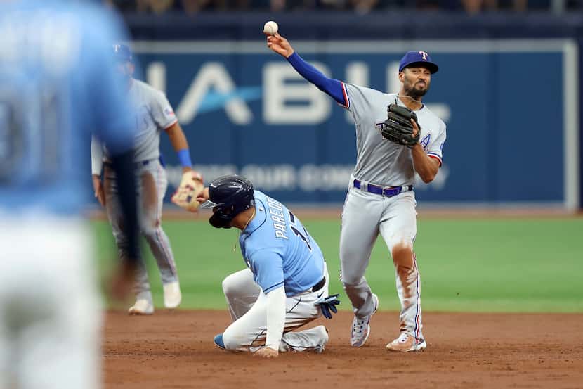 Texas Rangers' Marcus Semien throws over Tampa Bay Rays' Isaac Paredes to complete a double...
