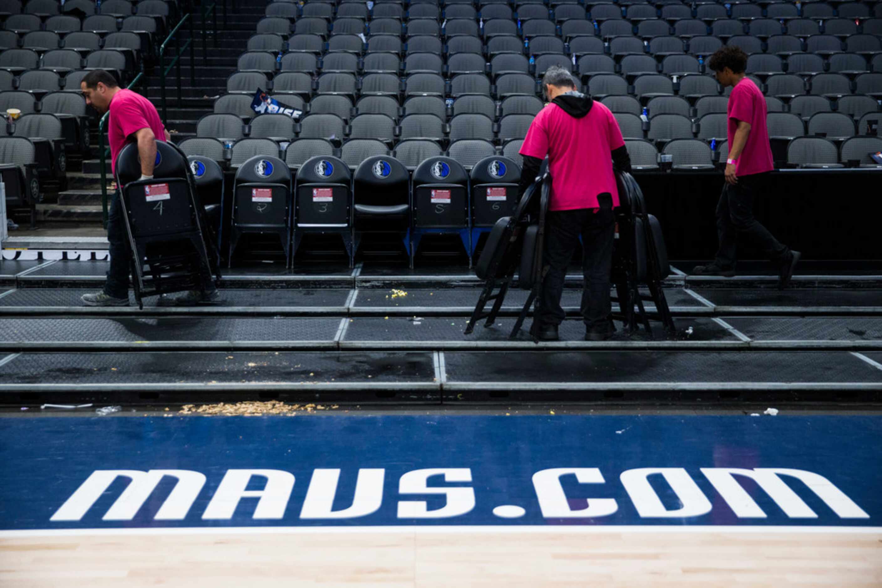 Crews remove chairs from the court after the Dallas Mavericks beat the Denver Nuggets 113-97...