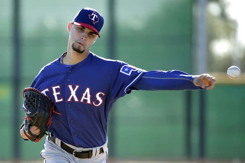 Texas Rangers pitcher Alex Claudio throws during spring training baseball practice Sunday,...